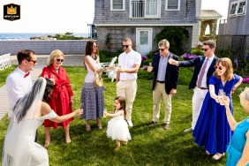 Cocktail hour outside a private residence in Biddeford Pool, Maine The couple's daughter rushes to be included in the toast.